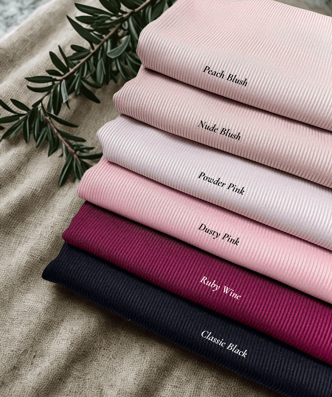 Flat lay of hijabs stacked including blus, pink, wine, black textured jersey hijab – Qalbi