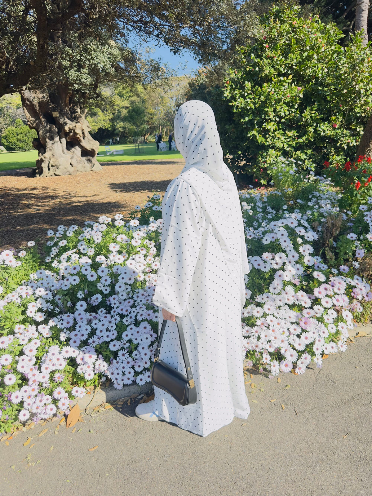 Women wearing Qalbi Polka dot abaya in soft white with black dots